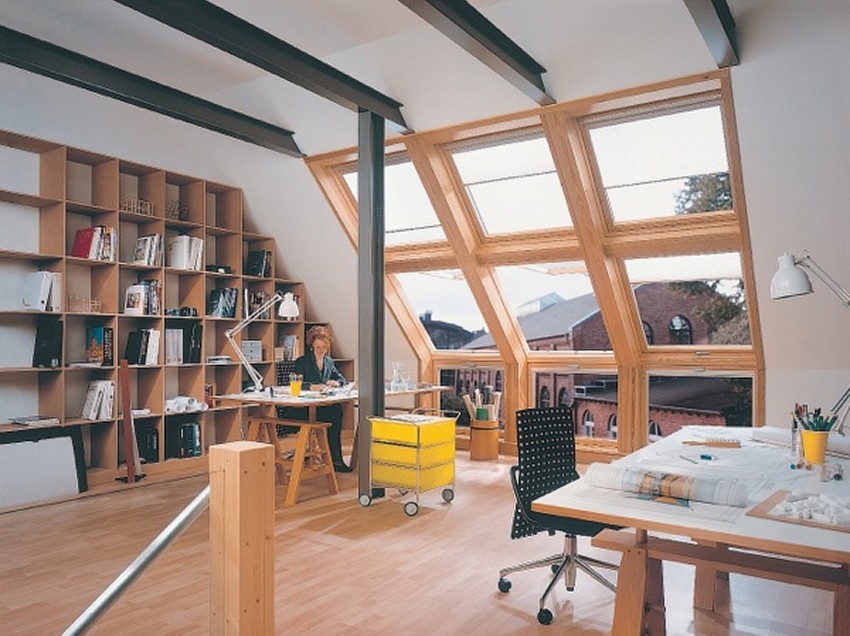 Beispiel für einen Innenraum mit schrägem Dachfenster, eine Person sitzt an einem Schreibtisch davor.