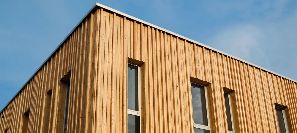 Ein Haus mit einer Vorhangfassade aus dunkelblauen Schindeln.