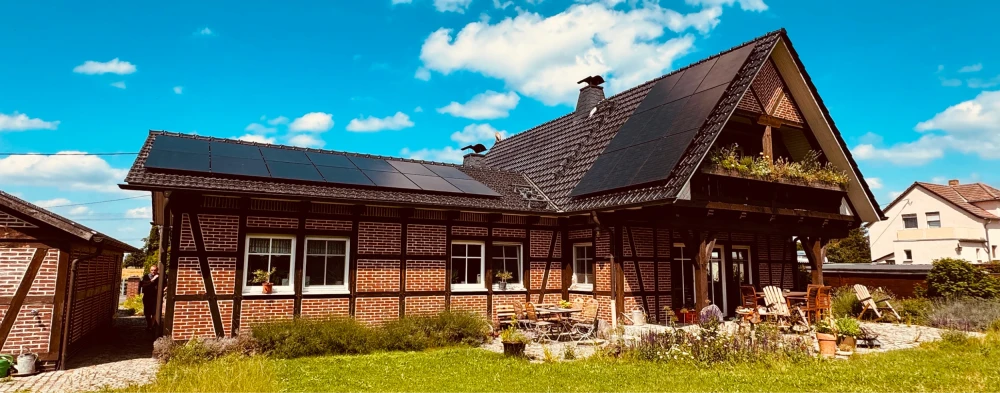 Ein Fachwerkhaus mit Spitzdach und großflächiger Photovoltaikanlage.